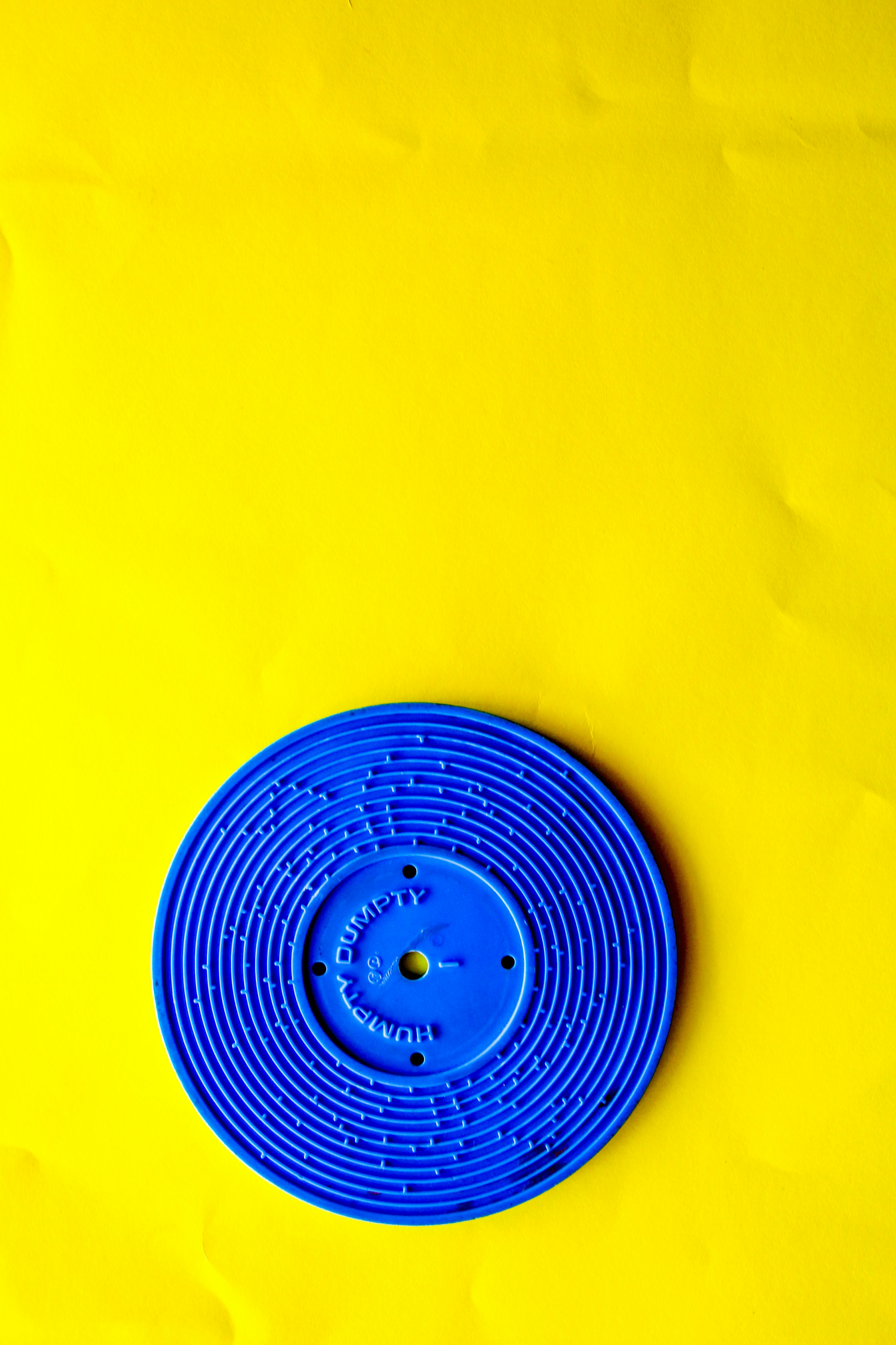 blue round plastic lid on yellow textile